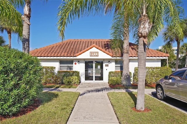 view of front of house featuring a front yard and french doors