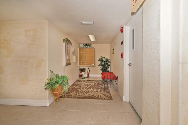 hallway with mail boxes and light tile patterned floors