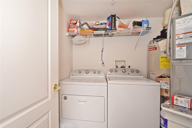 laundry room featuring washing machine and dryer and water heater