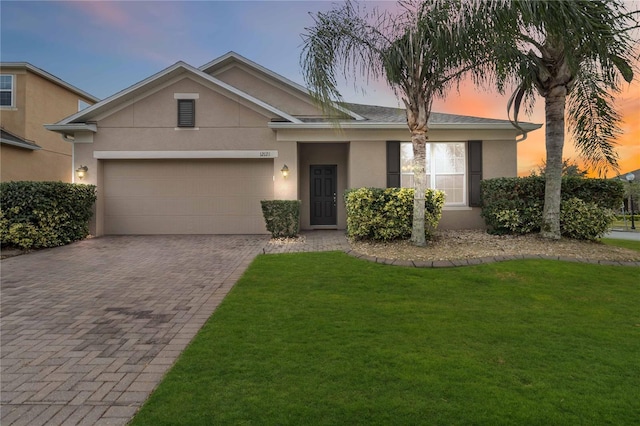 view of front of property with a yard and a garage