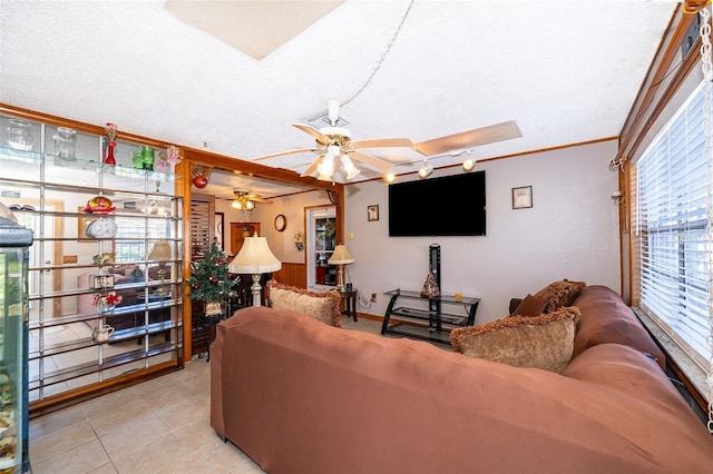 tiled living room with a textured ceiling, a wealth of natural light, and ceiling fan