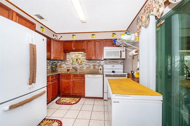 kitchen featuring backsplash, crown molding, sink, and white appliances