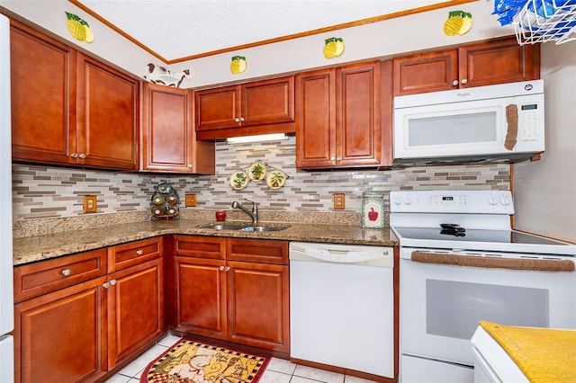 kitchen with decorative backsplash, light stone counters, white appliances, sink, and light tile patterned floors