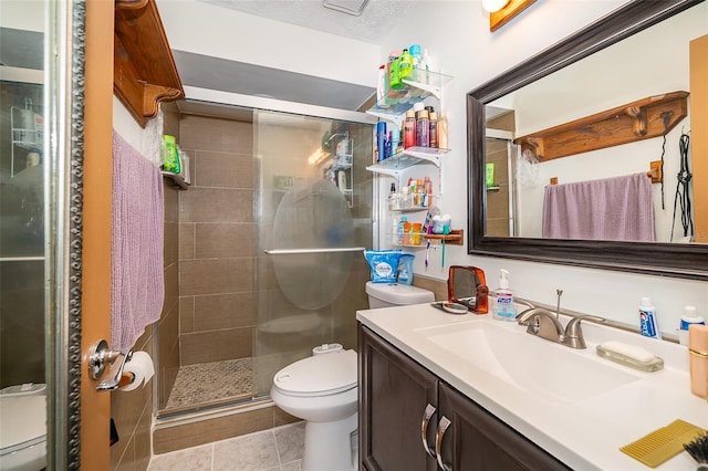 bathroom featuring tile patterned floors, walk in shower, vanity, a textured ceiling, and toilet