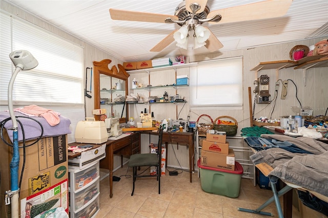 miscellaneous room with ceiling fan, light tile patterned floors, and wood walls