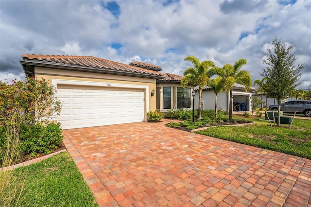 mediterranean / spanish home with a garage and a front lawn