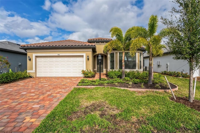 mediterranean / spanish house with a front yard and a garage