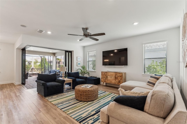 living room featuring ceiling fan and light hardwood / wood-style flooring