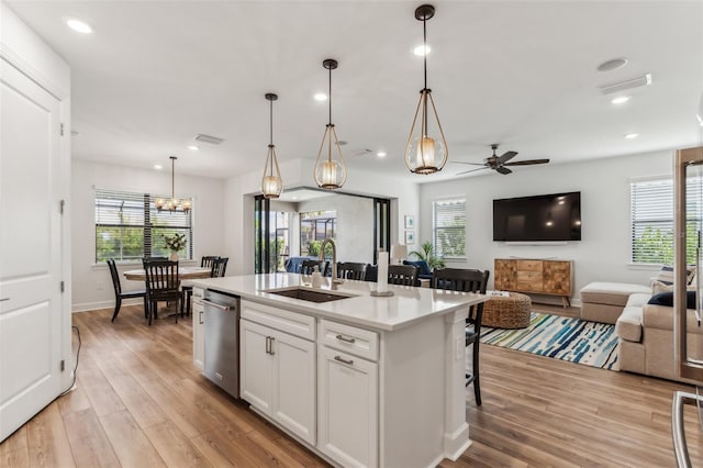 kitchen with pendant lighting, ceiling fan, white cabinetry, and a kitchen island with sink