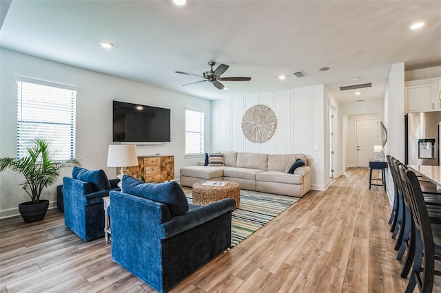 living room with ceiling fan and light hardwood / wood-style floors