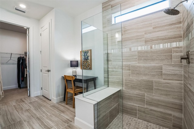 bathroom featuring a healthy amount of sunlight and tiled shower