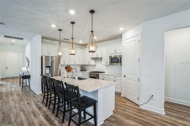 kitchen with white cabinetry, sink, an island with sink, and stainless steel appliances