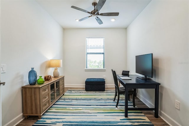 home office with ceiling fan and dark wood-type flooring