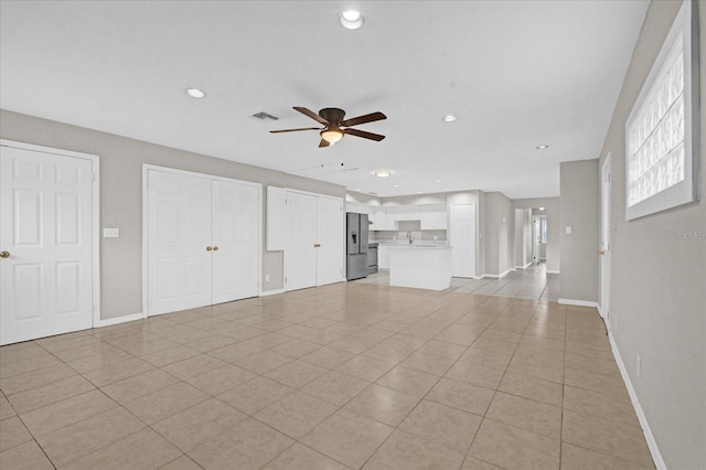 unfurnished living room with light tile patterned floors and ceiling fan