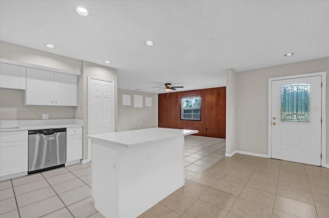 kitchen featuring a center island, white cabinets, stainless steel dishwasher, ceiling fan, and light tile patterned floors