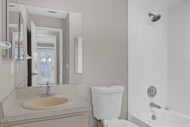 full bathroom with tiled shower / bath combo, toilet, and vanity