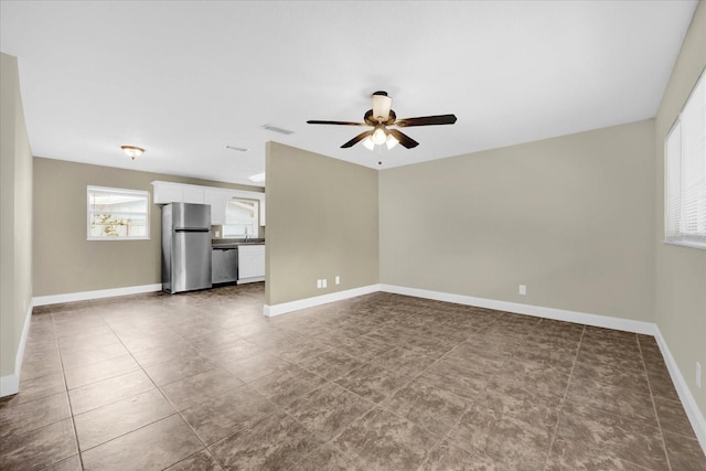 unfurnished living room with ceiling fan and sink