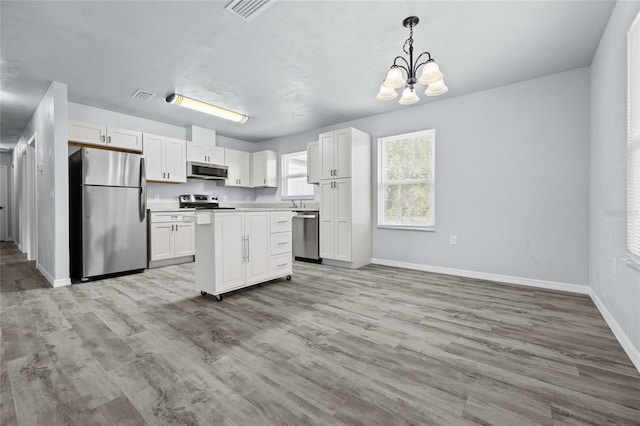 kitchen with white cabinetry, hanging light fixtures, a notable chandelier, and appliances with stainless steel finishes