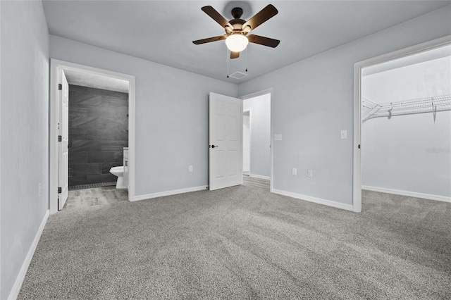 unfurnished bedroom featuring connected bathroom, carpet floors, a closet, and ceiling fan