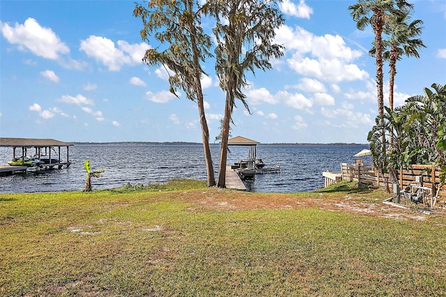 view of dock featuring a water view and a yard