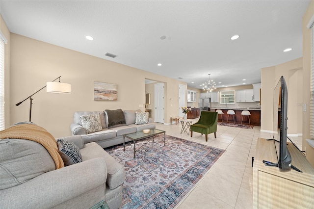 living room with light tile patterned floors, plenty of natural light, and a notable chandelier