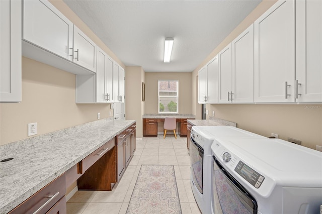 laundry area featuring cabinets, separate washer and dryer, and light tile patterned flooring