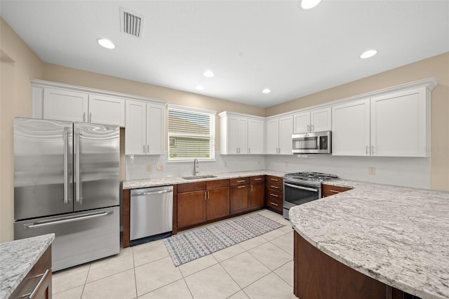 kitchen with sink, white cabinetry, stainless steel appliances, and light tile patterned floors