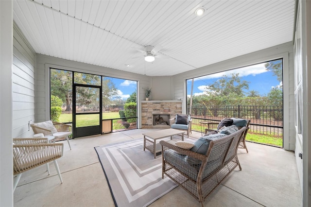 sunroom / solarium with ceiling fan and a fireplace