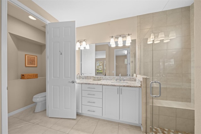 bathroom featuring tile patterned floors, vanity, an enclosed shower, and toilet