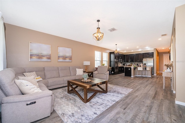 living room with hardwood / wood-style floors and an inviting chandelier