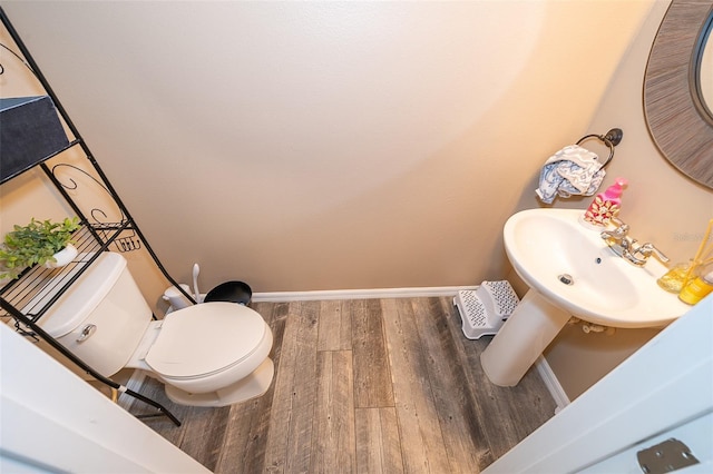 bathroom with hardwood / wood-style flooring, toilet, and sink