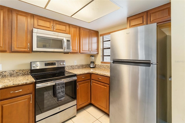 2007 Disney Mgm Studio Ct, Kissimmee, FL 34746 - kitchen with stainless steel appliances, brown cabinets, and light tile patterned flooring