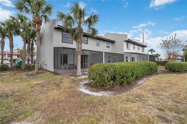 2007 Disney Mgm Studio Ct, Kissimmee, FL 34746 - rear view of property with a sunroom, stucco siding, and a yard