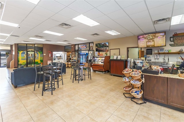 interior space with a drop ceiling and light tile patterned flooring