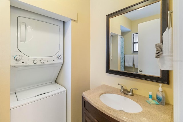 laundry area with stacked washer / drying machine and sink