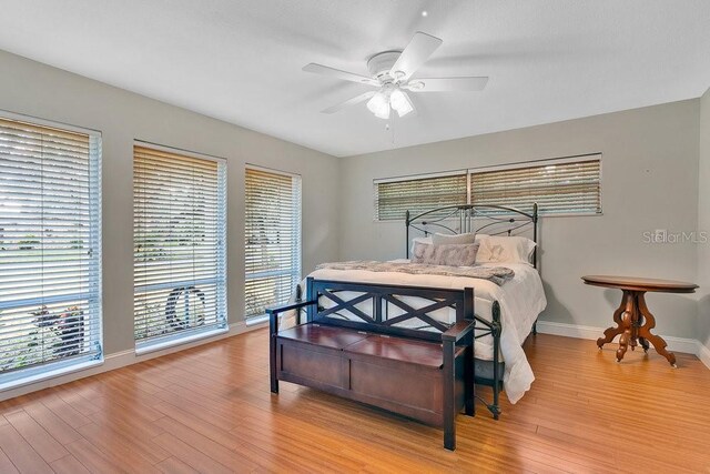 bedroom featuring light wood-style floors, ceiling fan, and baseboards