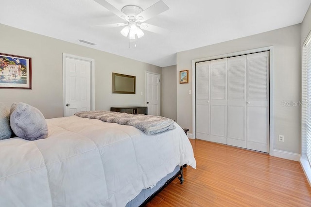 bedroom featuring a closet, visible vents, ceiling fan, light wood-type flooring, and baseboards