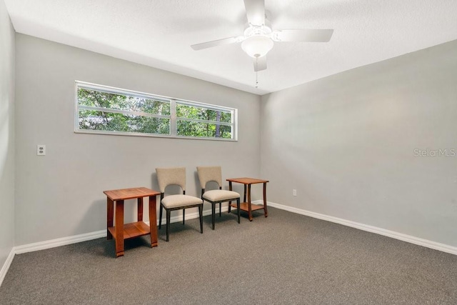 living area featuring a ceiling fan, carpet flooring, a textured ceiling, and baseboards