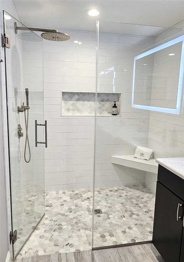 full bathroom featuring a shower stall, vanity, and wood finished floors