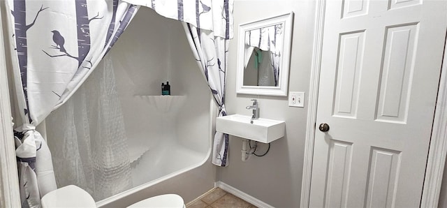 full bathroom with shower / tub combo with curtain, toilet, a sink, baseboards, and tile patterned floors