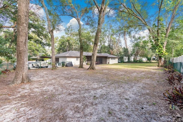 view of yard featuring a carport and fence