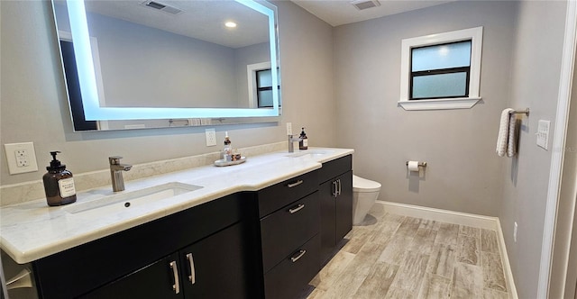 full bathroom featuring visible vents, a sink, toilet, and wood finished floors