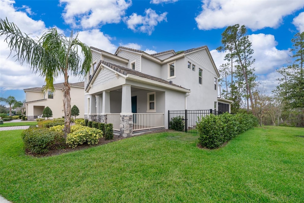 view of front of property featuring a front lawn, a porch, fence, and stucco siding