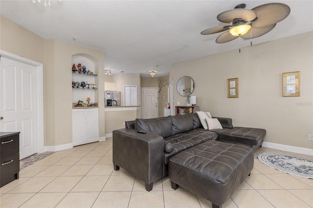 tiled living room featuring ceiling fan and built in features