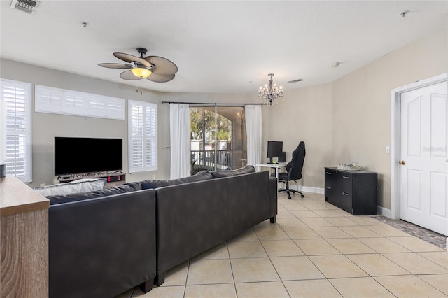 tiled living room with ceiling fan with notable chandelier and a wealth of natural light