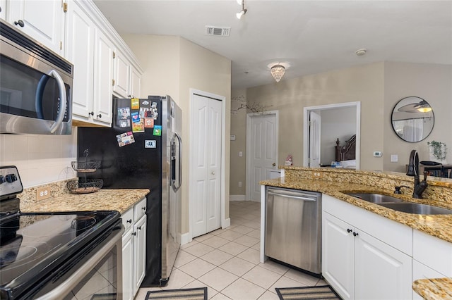 kitchen with light stone countertops, white cabinetry, sink, stainless steel appliances, and light tile patterned floors