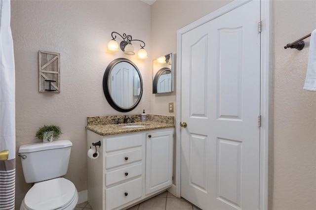 bathroom featuring tile patterned flooring, vanity, and toilet