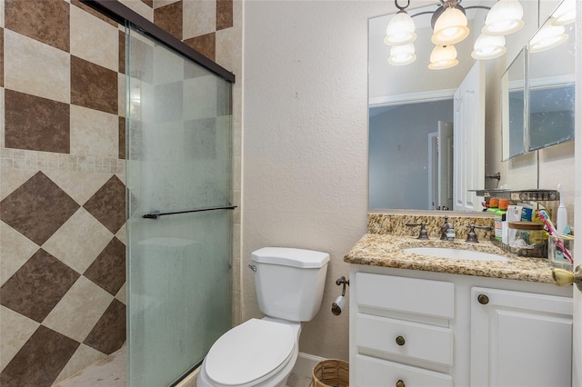 bathroom featuring an inviting chandelier, vanity, an enclosed shower, and toilet