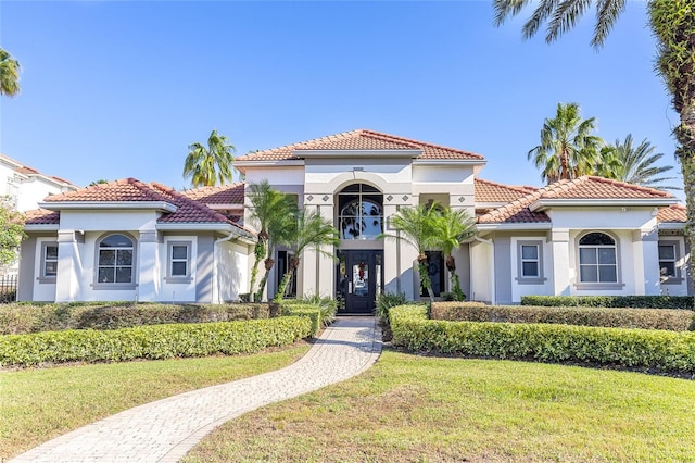 mediterranean / spanish home featuring a front yard