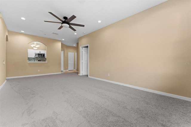 empty room with carpet and ceiling fan with notable chandelier